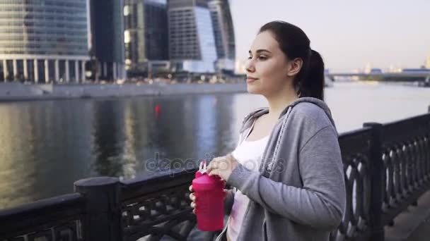 Jovem mulher em um sportswear água potável na cidade de Moscou — Vídeo de Stock