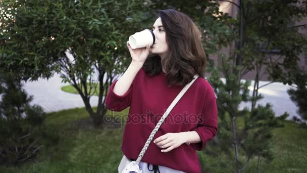 Fiatal lány kávét iszik, és megfelel a barátnője. Ölelés — Stock videók