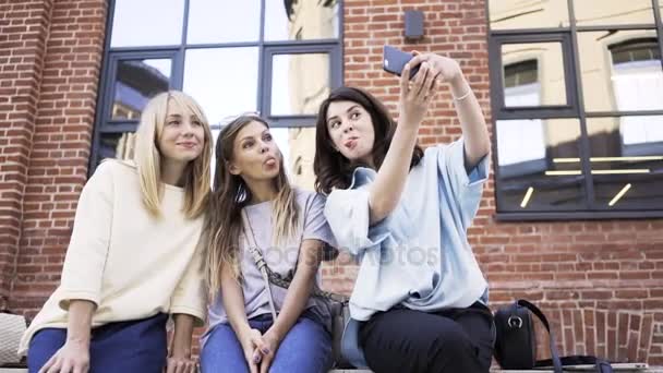 Három fiatal nők pofákat, és vesz egy selfie, egy nyári napon — Stock videók