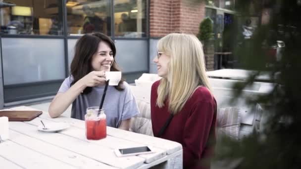 Dos novias hablando y tomando café en un café al aire libre — Vídeos de Stock