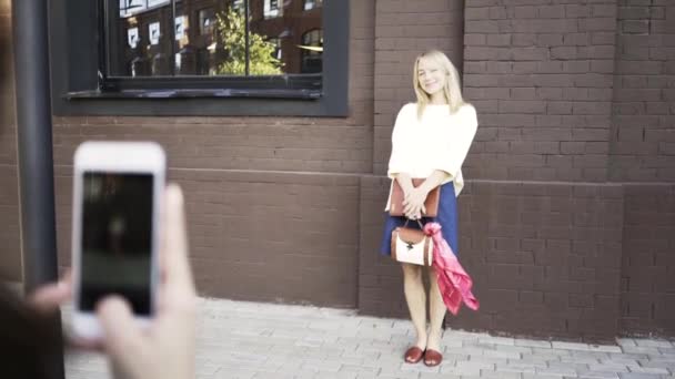 Donna fotografa scattare foto di una modella bionda con il suo telefono — Video Stock