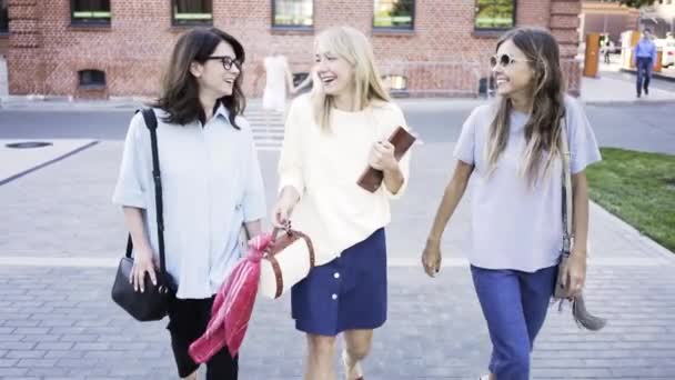 Tres mujeres jóvenes están caminando después del trabajo en un día de verano — Vídeo de stock