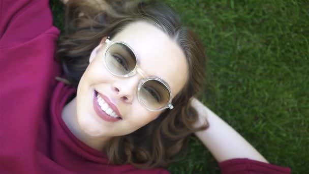 Top view of young woman lying on grass — Stock Video