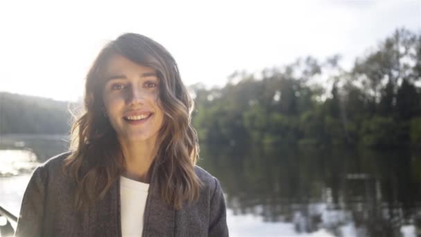 Smiling young brunette on a boat, a river — Stock Video