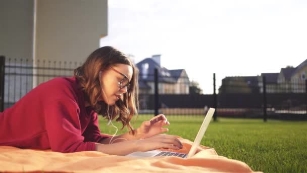 Jeune fille en lunettes entrant son numéro de carte de crédit, un ordinateur portable, un jardin — Video