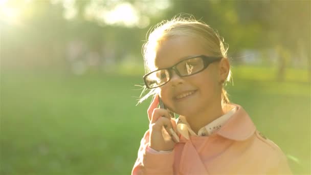 Linda niña en rosa de pie y hablando por teléfono — Vídeos de Stock