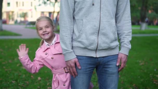 Niña escondida detrás de su madre en un parque de verano — Vídeo de stock