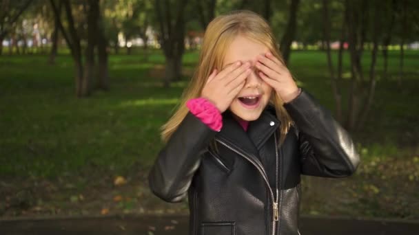 Κοριτσάκι, κλείνοντας τα μάτια της με τα χέρια της και το άνοιγμά τους — Αρχείο Βίντεο