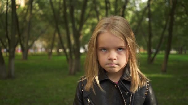 Menina em uma jaqueta de couro alimentado em um parque — Vídeo de Stock