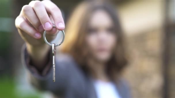 Неузнаваемая молодая женщина показывает новый ключ от дома — стоковое видео