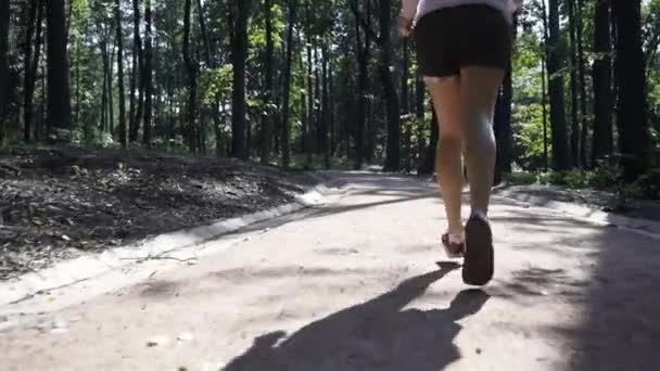 Joggedame i en park i sakte film – stockvideo