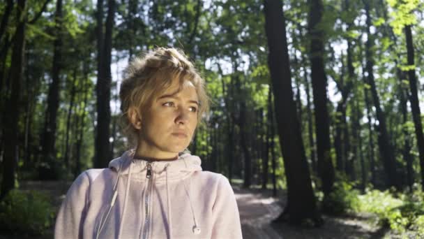 Femme blonde avec des taches de rousseur dans une forêt tournant et vous souriant — Video