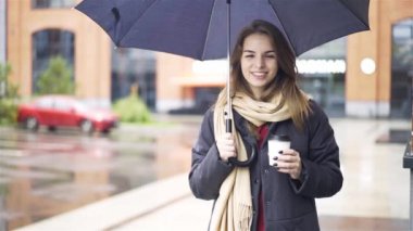 Neşeli kadın kahve içme şemsiyesi altında