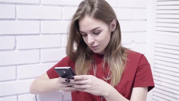 Calm young woman in red t shirt texting zoom in — Stock Video