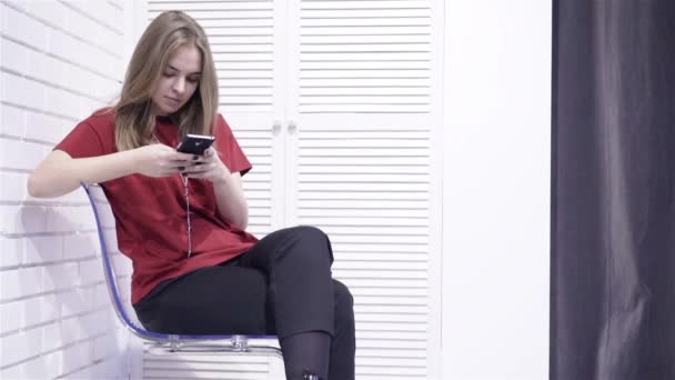 Young woman in red t shirt texting — Stock Video