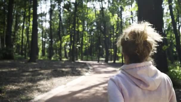 Visão traseira de uma jovem mulher correndo no verão — Vídeo de Stock