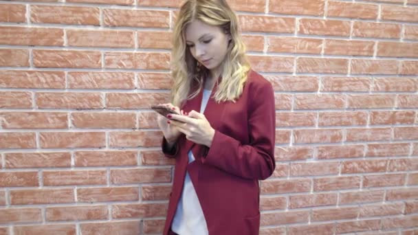 Приваблива блондинка-бізнесмен, що витирає і смс — стокове відео