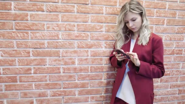 Lachende blonde zakenvrouw jatten en SMS — Stockvideo