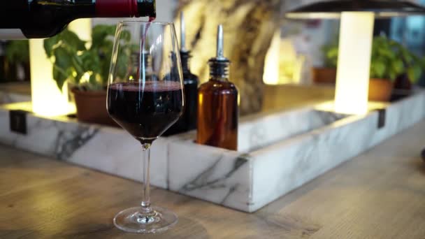 Kvinnan tar ett rött vin glas hälls av servitör på en restaurang — Stockvideo