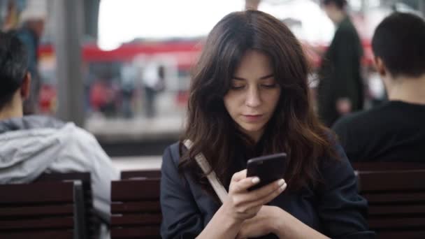 Mooie jonge toeristische texting op een bankje in het Centraal Station van Berlijn — Stockvideo