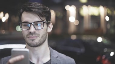 Gece sokakta bir cep telefonu olan bir adam bir closeup