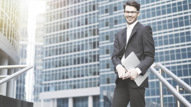 Açık hava kahkahalar içinde duran genç bir işadamı