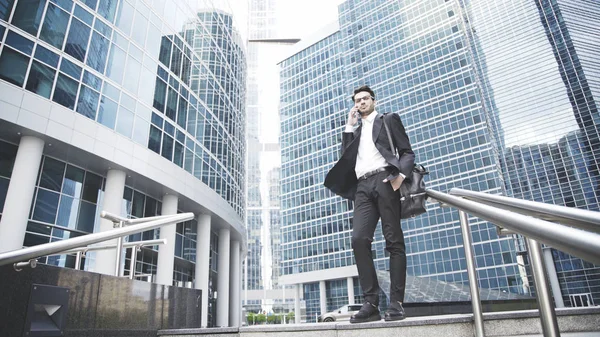 Un joven empresario está hablando por teléfono en las escaleras. — Foto de Stock