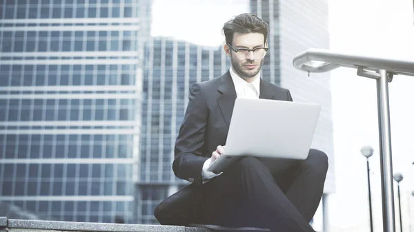 Zakenman in de open lucht met een laptop werkt — Stockfoto