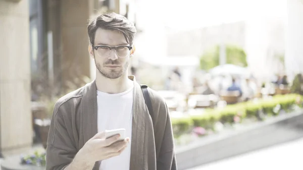 Un joven serio entrega los ojos del celular a la cámara — Foto de Stock