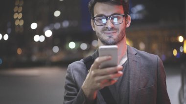Gece sokakta bir cep telefonu olan bir adam bir closeup