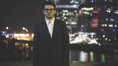 Eyeglasess gece siyah bir takım elbise giymiş genç bir işadamı
