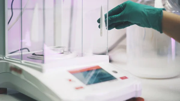 Un technicien de laboratoire ouvre à la main du matériel chimique . — Photo