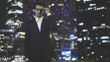 Eyeglasess gece siyah bir takım elbise giymiş genç bir işadamı