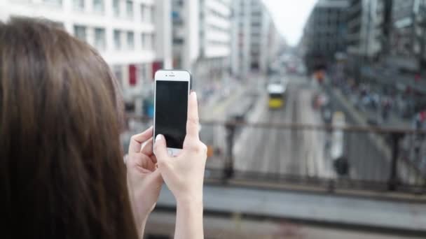 Молодая женщина фотографирует немецкий город с помощью мобильного телефона — стоковое видео