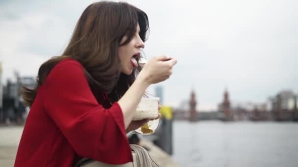 Mulher bonita comendo em uma rua alemã no verão, pan shot — Vídeo de Stock