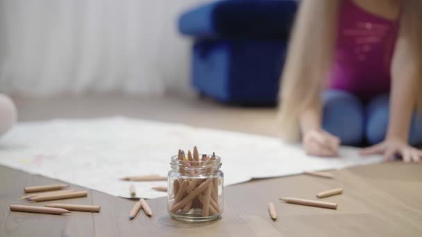 Dvě malé holčičky kreslení velký obrázek na podlaze pomocí tužky rozostření — Stock video