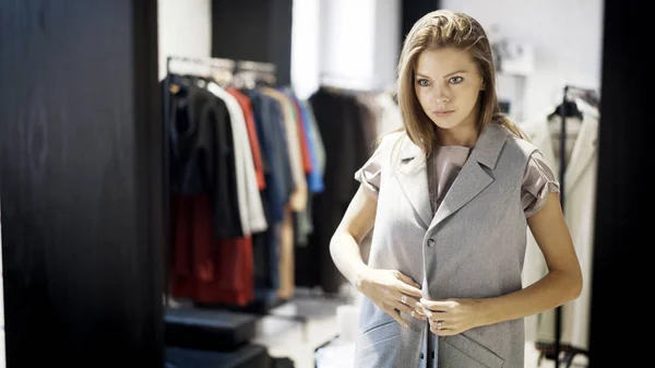 Une jeune fille essaie une veste dans un magasin — Photo