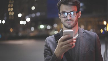 Gece sokakta bir cep telefonu olan bir adam bir closeup