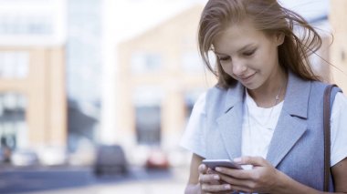 Bir genç gülümseyen mutlu kızı rahat bir telefon yazarak bir ceket giymiş