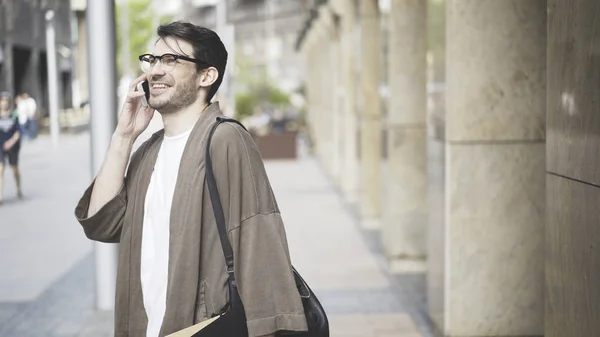 Hombre vestido con ropa casual se ríe y habla por teléfono — Foto de Stock