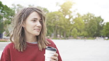 Bir genç sevimli casual esmer kız sabah açık havada kahve içiyor
