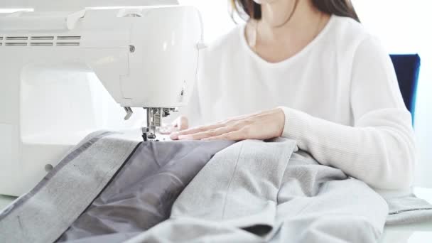 Невпізнавана жінка в білому шитті на швейній машині — стокове відео