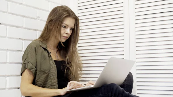 Genç güzel model kız öğrenci bir closeup katta oturan dizüstü bilgisayar ile çalışma — Stok fotoğraf