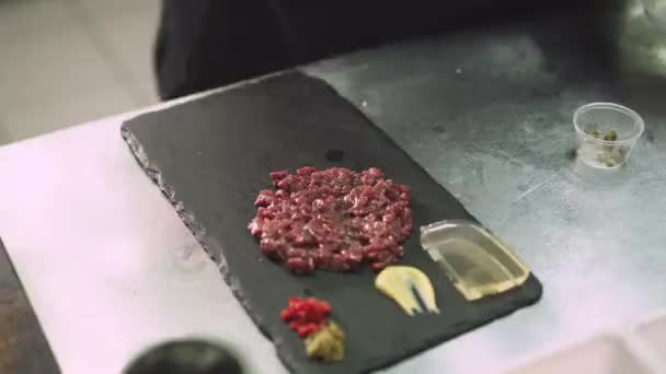 Крупный план повара, добавляющего чеснок на блюдо с нарезанным тунцом — стоковое видео
