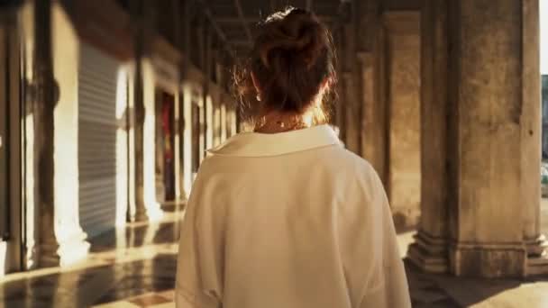 Retrato em tempo real de uma menina elegante andando ao longo da galeria exterior em Veneza, Itália — Vídeo de Stock