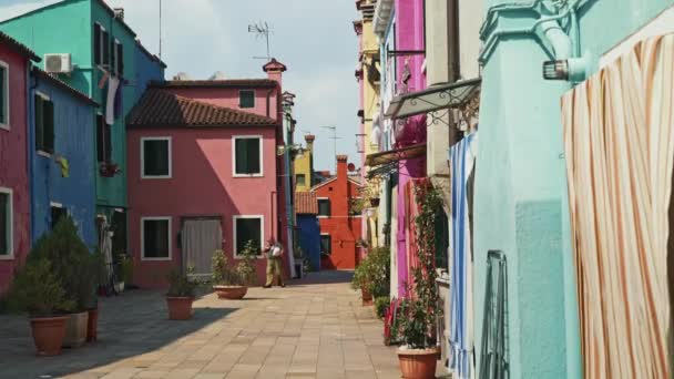BURANO - 14 DE JULIO: Toma en tiempo real de una calle con casas coloridas en la isla de Burano en Italia. La isla de Burano es famosa por sus coloridas casas, 14 de julio de 2019 en Burano, Italia . — Vídeos de Stock