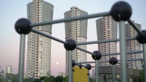 Tilt down shot van vier moderne residentiële buldings op zonsondergang achtergrond — Stockvideo