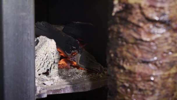 Close up carvões de tiro de mão na máquina shawarma grill e carne de vaca em um espeto — Vídeo de Stock