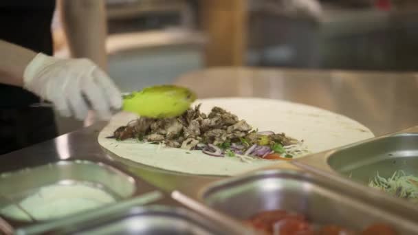 Tirador de mano de manos de chef en guantes blancos haciendo doner en pita — Vídeo de stock