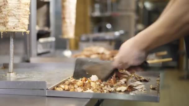 Închideți bucătarul care taie carnea de pui pentru shawarma unei plăci metalice — Videoclip de stoc